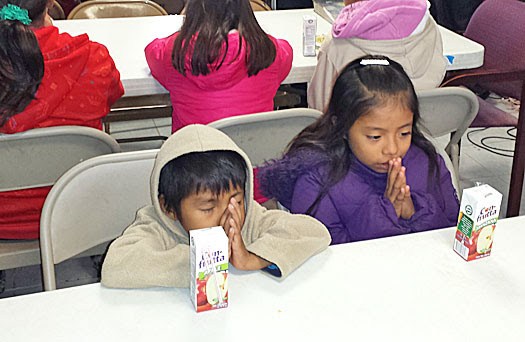 Kids praying before a meal at the Christmas fiestas in Mexico