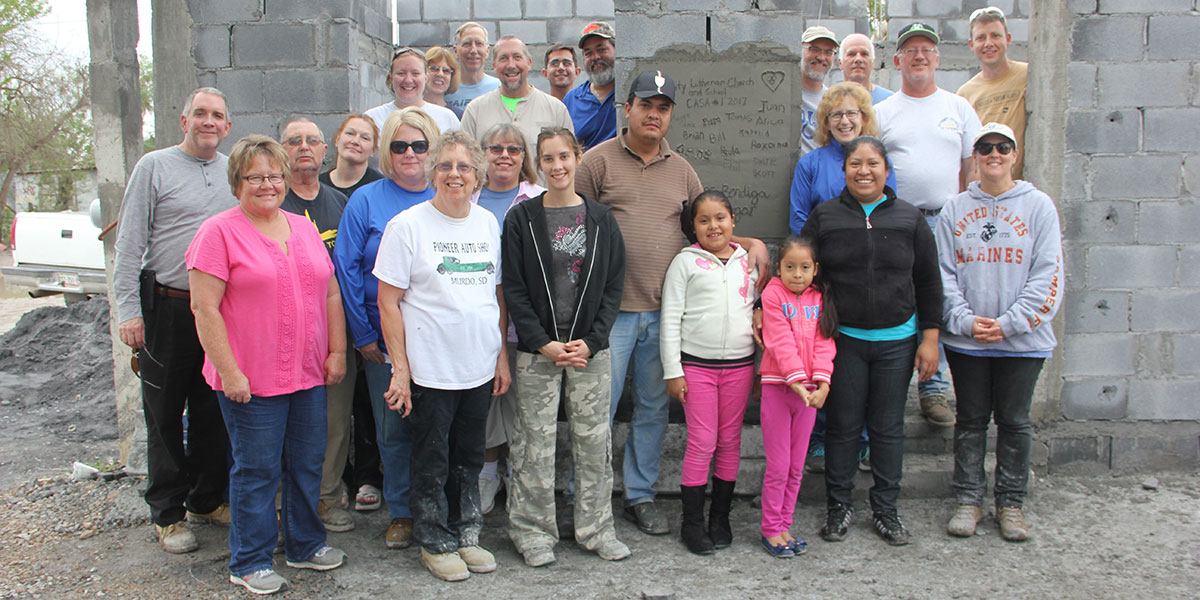 A team and a family in front of a completed house in Reynosa