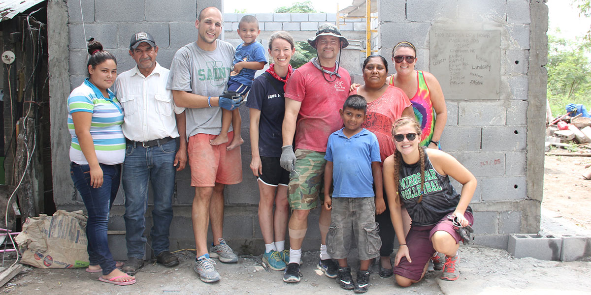 A group and a family in front of a recently completed house in Mexico
