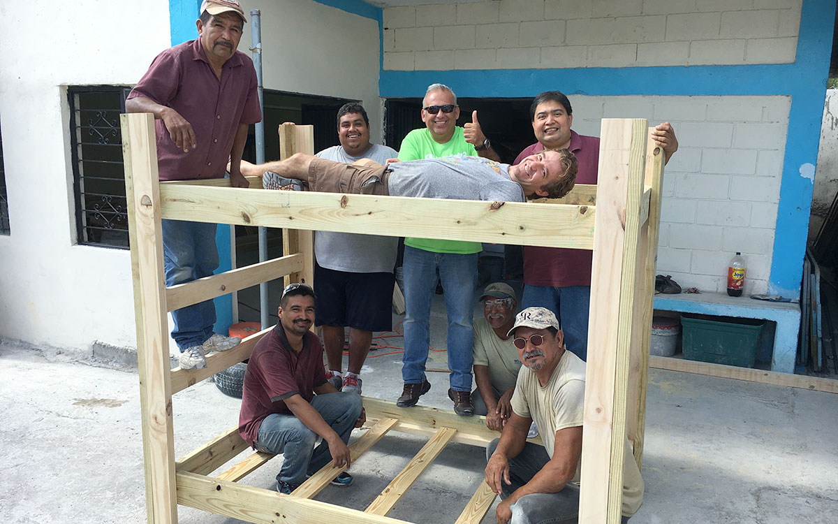 Staff in Reynosa with a newly made bunk bed in the woodworking shop