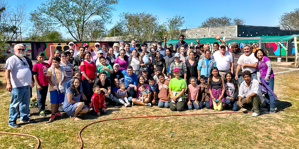 A team and the kids and adults of the church in Naranjito on a beautiful day