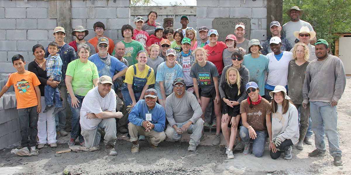 A team and a family in front of a completed house in Reynosa
