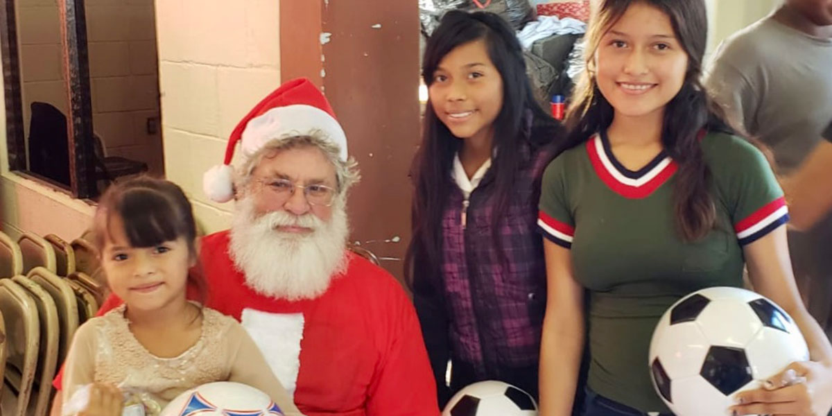 Girls with their new soccer balls and Santa at the Christmas fiesta in Reynosa