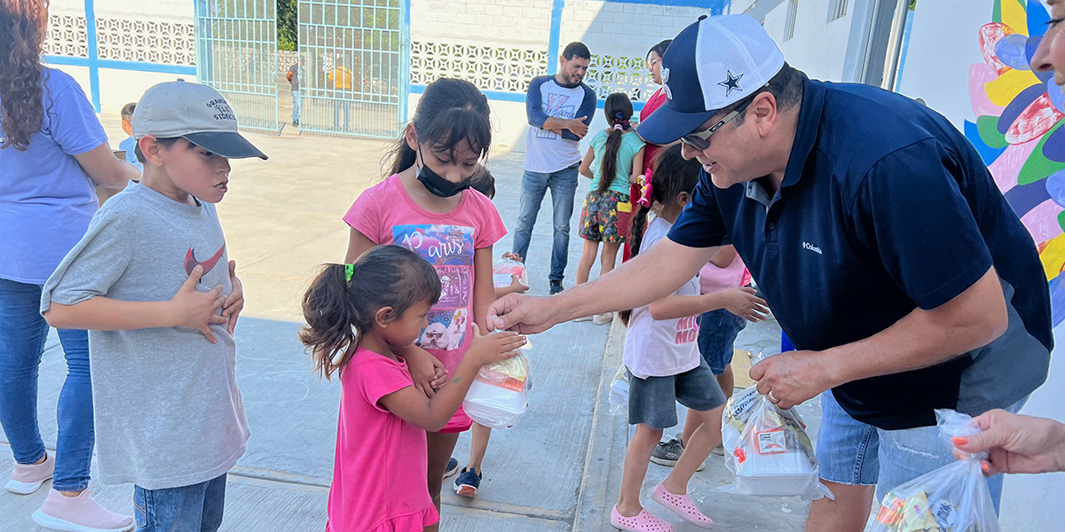 Friends from McAllen Texas distributing meals to the kids at the childrens nutrition program in Reynosa Mexico Friends from McAllen Texas distributing meals to the kids at the childrens nutrition program in Reynosa Mexico