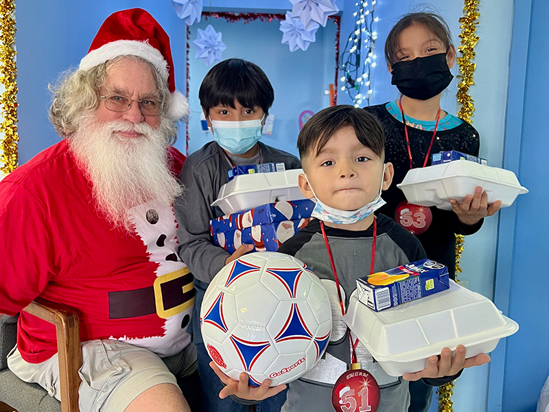 Kids at last years Christmas fiesta with their meals and toys and Santa Kids at last years Christmas fiesta with their meals and toys and Santa