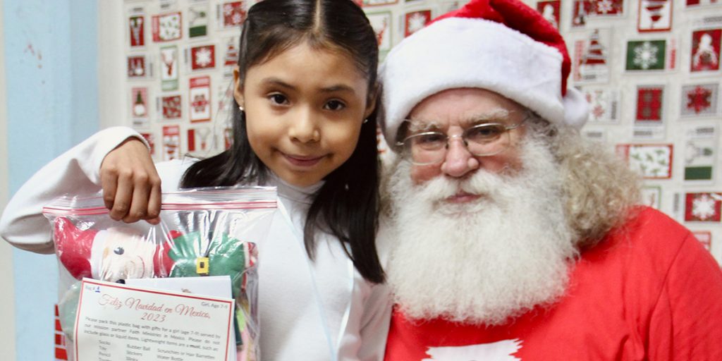 A kid with her gift and Santa at our Christmas fiesta in Naranjito Mexico