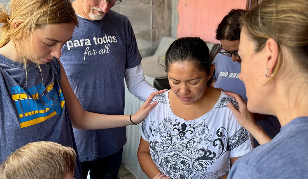 Friends from McAllen praying over a woman in Reynosa Mexico